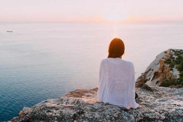 Woman tapping for calm at sunset